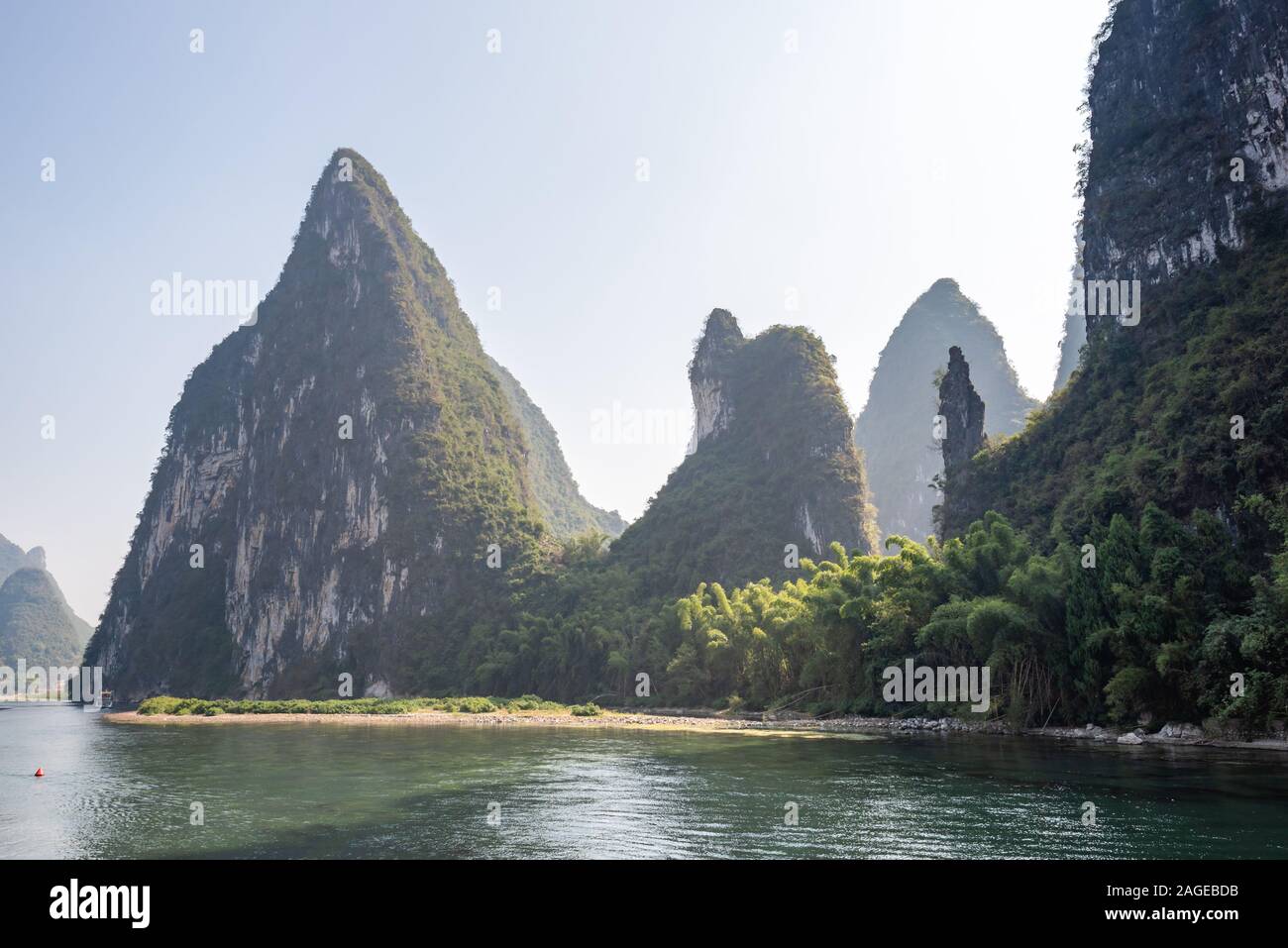 Boat on Li river cruise and karst formation mountain landscape in the fog between Guiling and Yangshuo, Guangxi province, China Stock Photo
