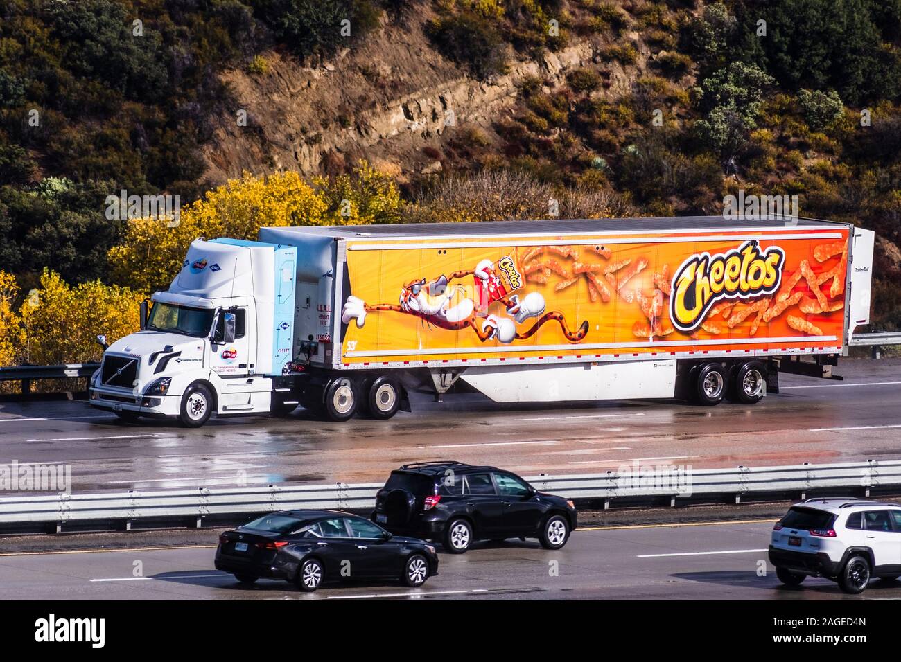 Dec 8, 2019 Los Angeles / CA / USA - Cheetos branded truck driving on the freeway; Cheetos is a brand of cheese-flavored puffed cornmeal snacks made b Stock Photo