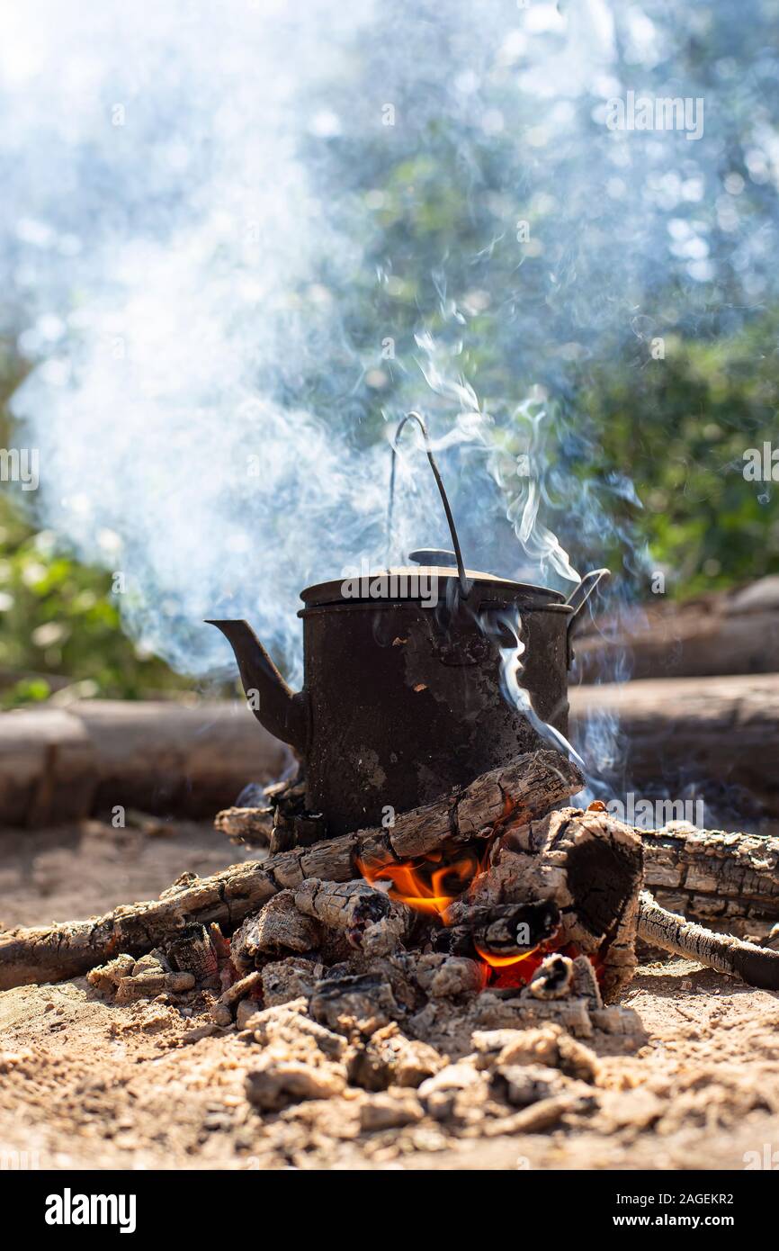 https://c8.alamy.com/comp/2AGEKR2/boiling-sooty-kettle-with-hot-drink-stands-on-a-campfire-in-the-smoke-in-a-forest-2AGEKR2.jpg