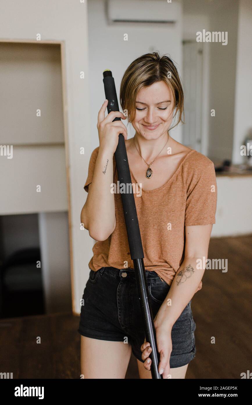 Woman with a broom standing in her new home Stock Photo