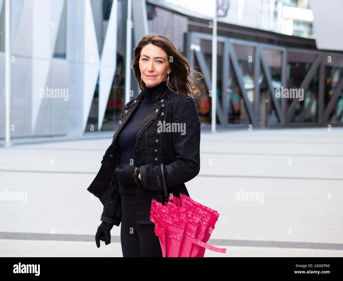 Woman in black suit walking in city Stock Photo