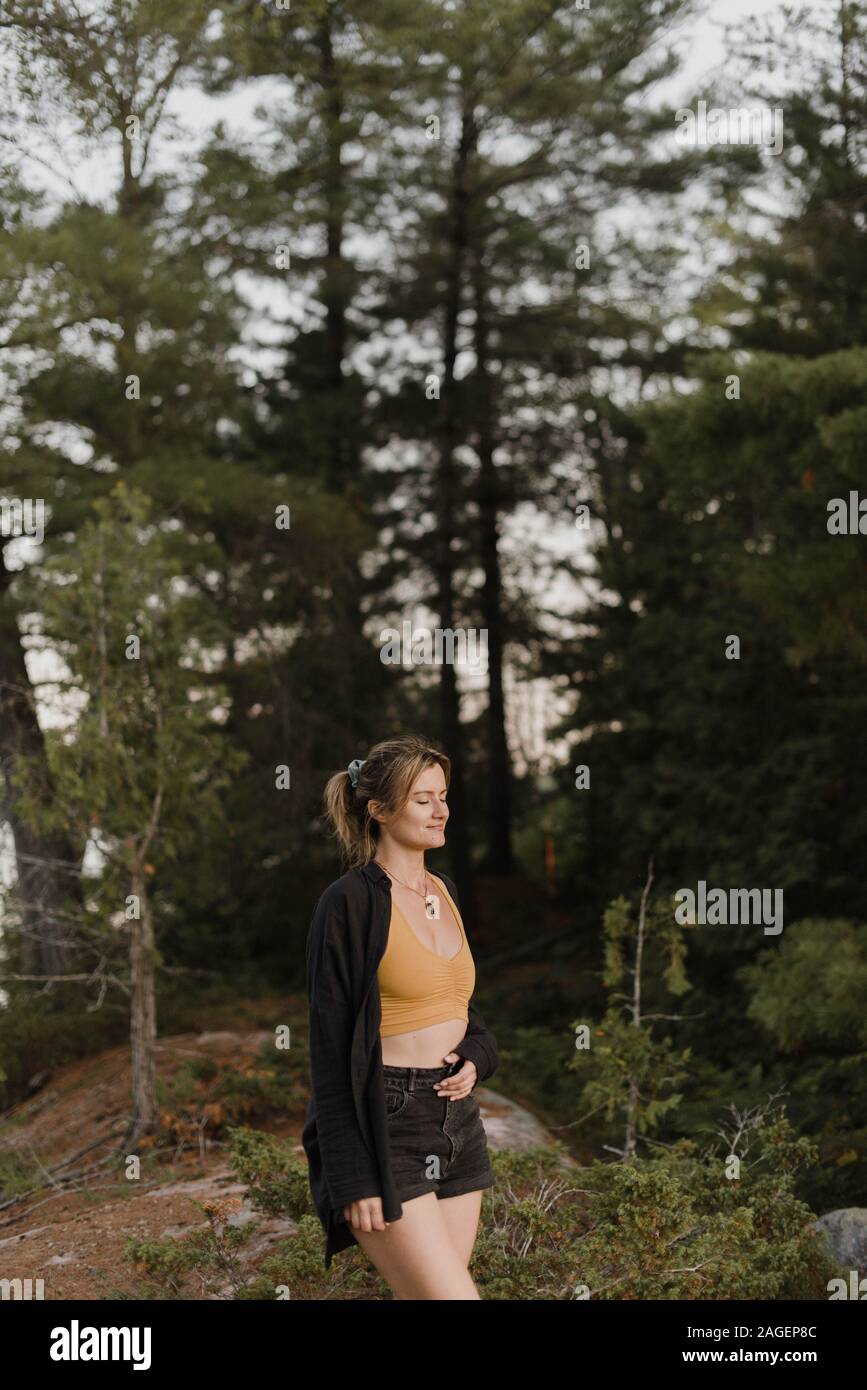 Woman relaxing with eyes closed in forest Stock Photo - Alamy