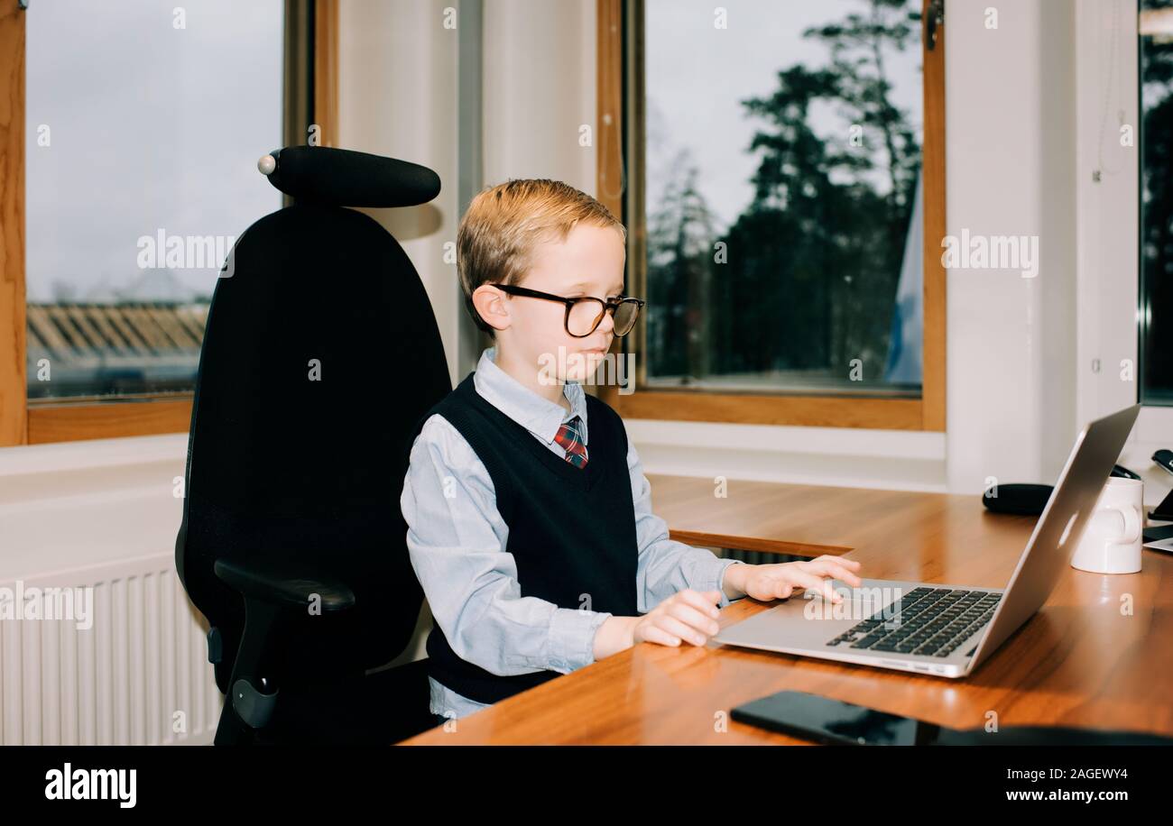 young boy working in his dads office working on a computer Stock Photo