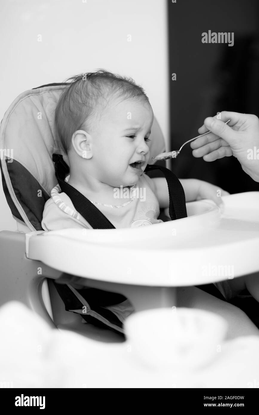 baby eating from a spoon eats milk porridge Stock Photo