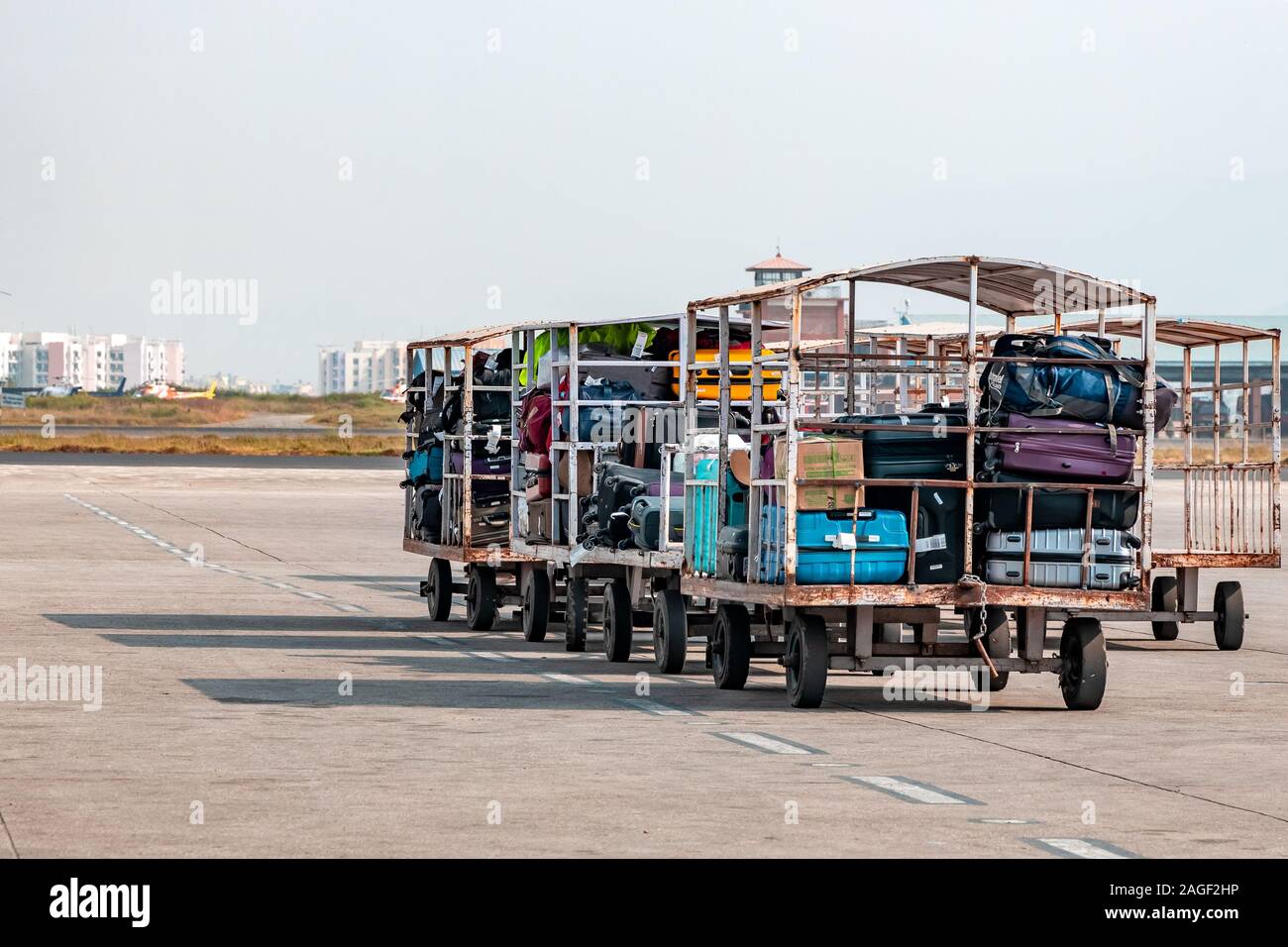 Luggage waiting on taxiway to be loaded on airplane at an airport Stock Photo