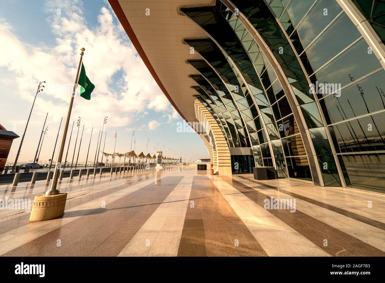 Saudi flag waving in the wind in front of the brand new Terminal 1 at the King Abdulaziz International Airport (JED) in Jeddah, Saudi Arabia Stock Photo
