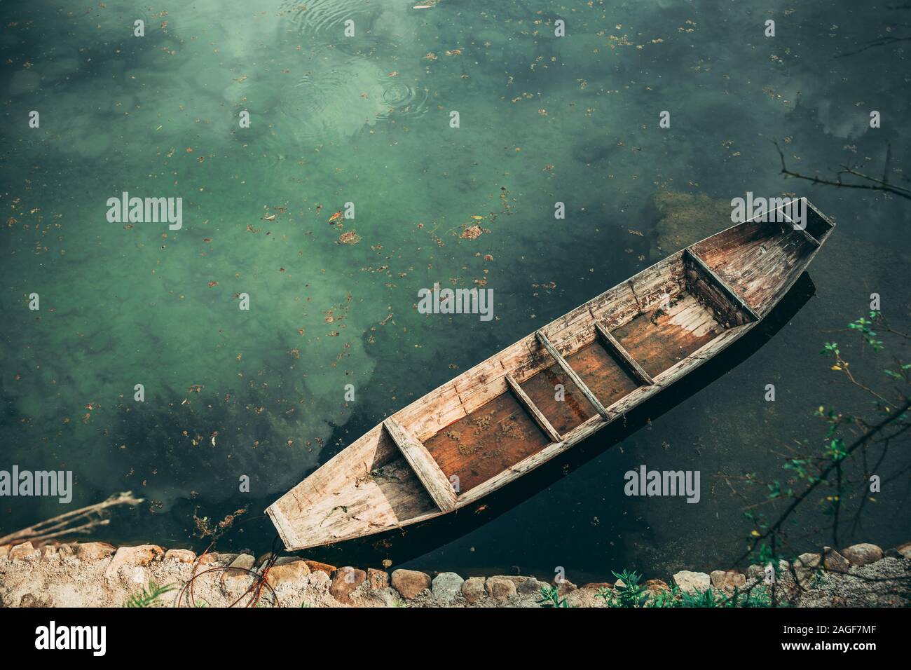 Small old wooden boat on the riverbank in Wellingyuan, China Stock Photo
