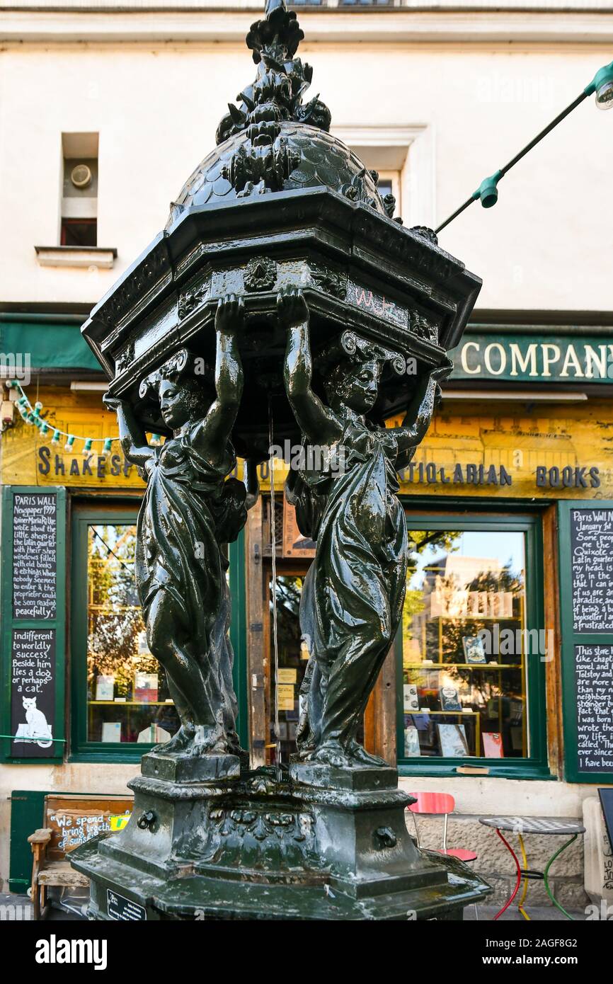 A Wallace fountain (19th century) in front of the famous Shakespeare and Company historical bookstore on the Rive Gauche (Left Bank), Paris, France Stock Photo
