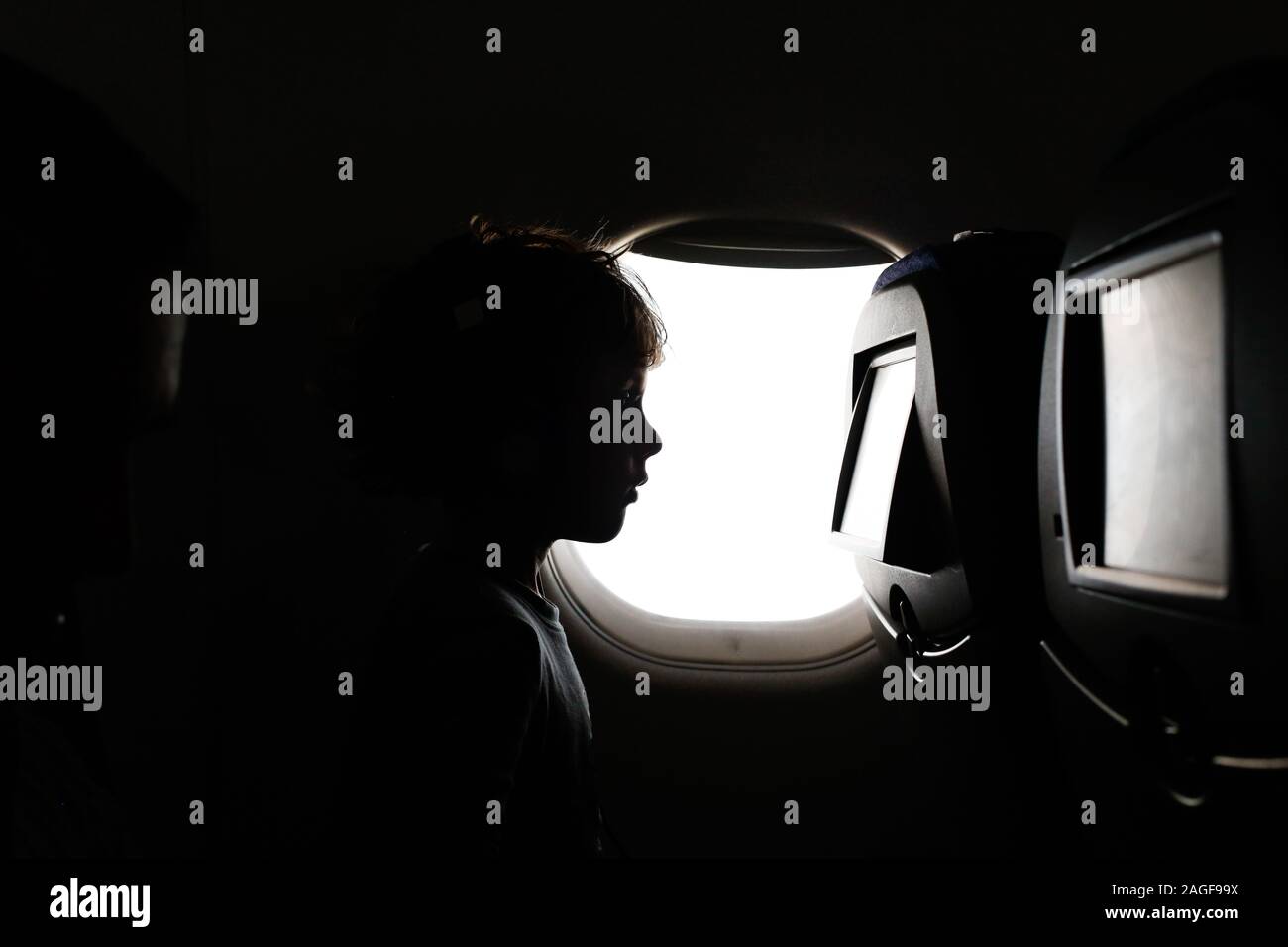 Little boy sitting on the plane watching a movie Stock Photo