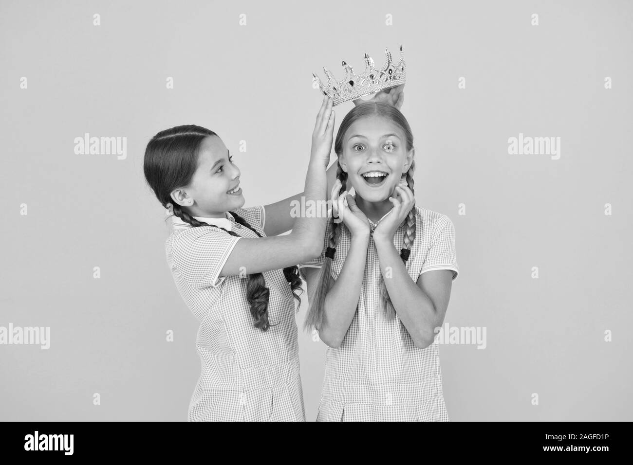 She is the best. Happy schoolgirls and golden crown symbol of success. Success and respect. Little princess. Motivational award for school children. Succeed in education. Celebrating success. Stock Photo
