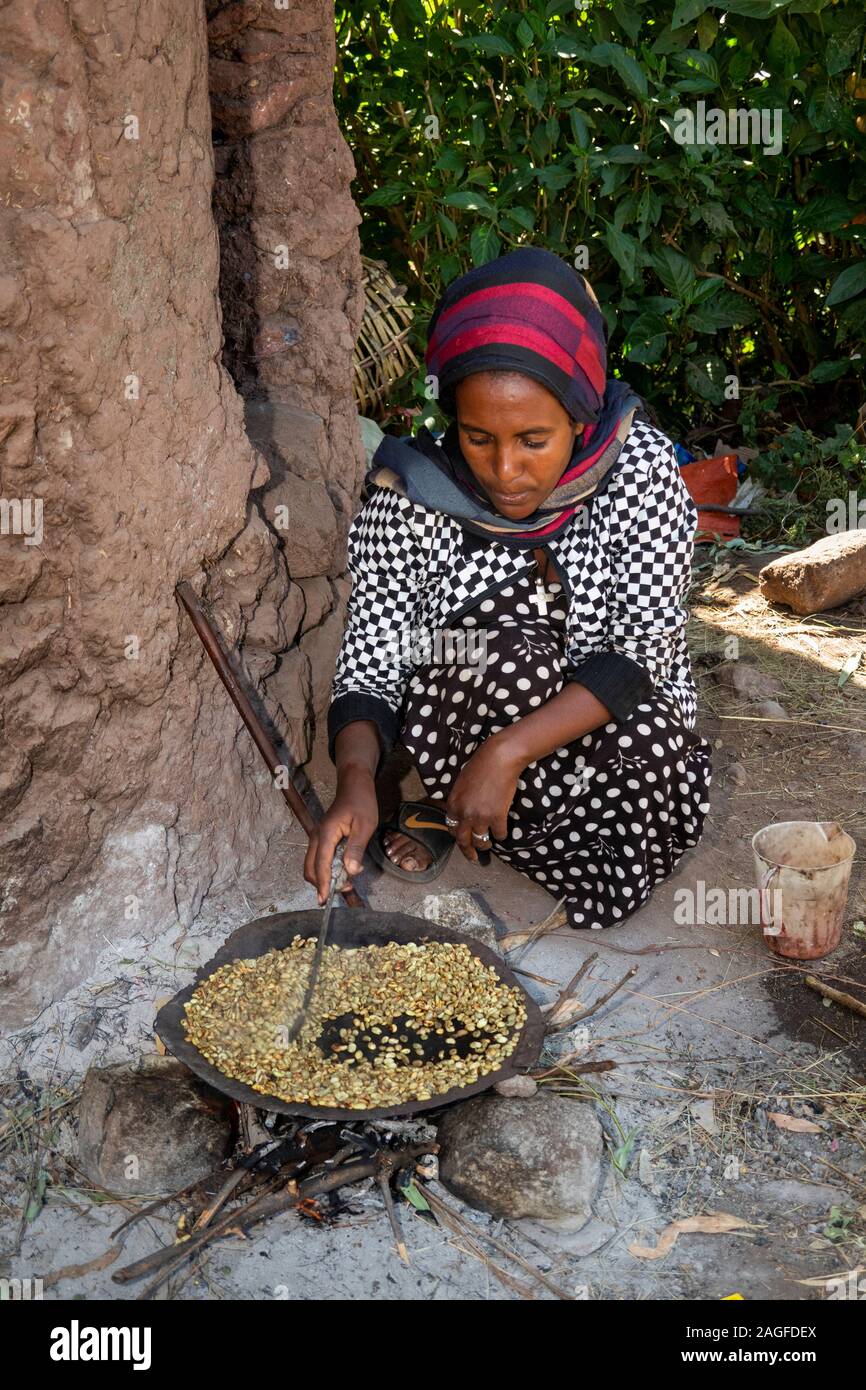 Ethiopia, Amhara Region, Lalibela, historic town, woman roasting fresh coffee beans to make buna Stock Photo