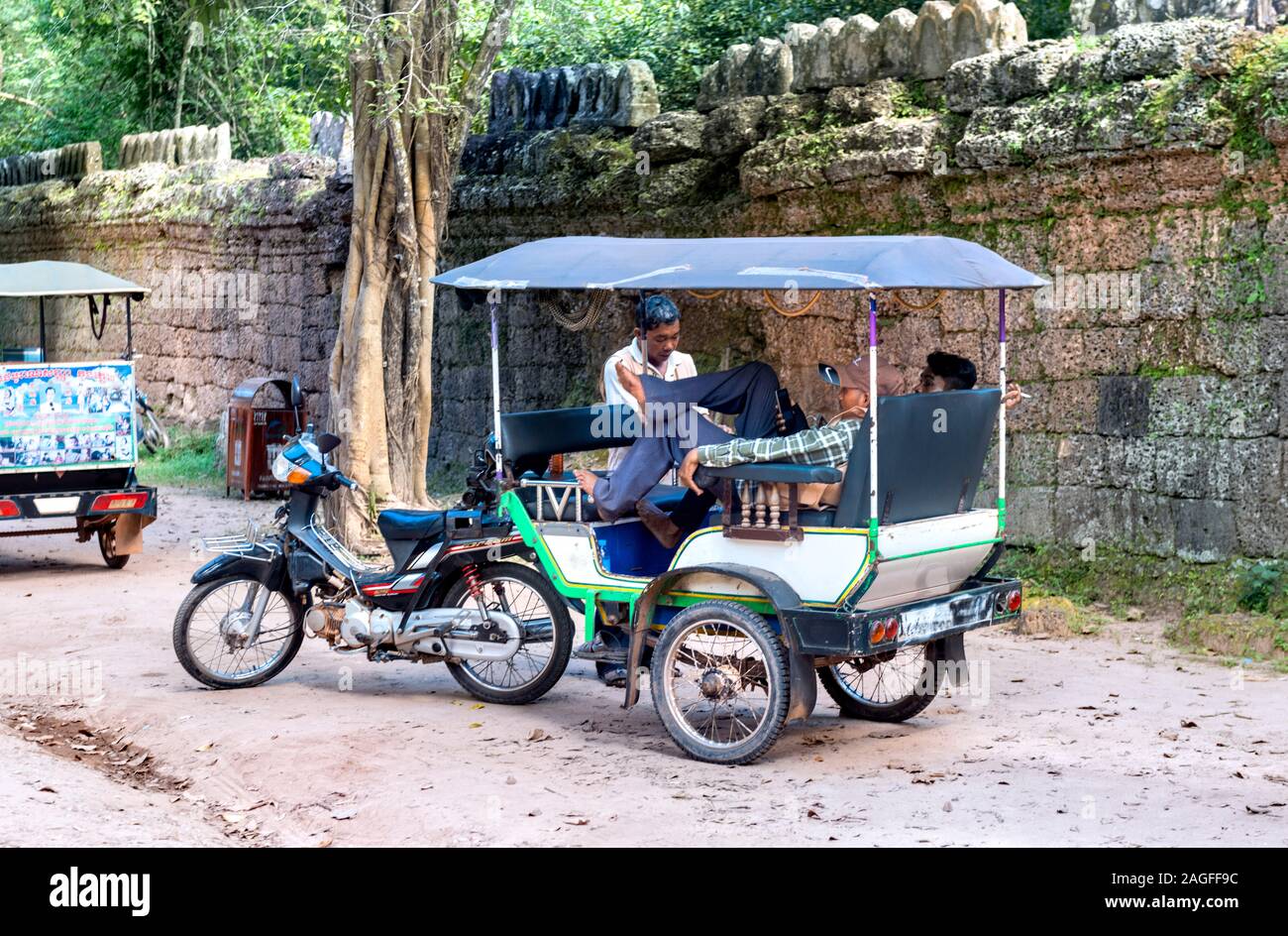 Cambodian rickshaw drivers relaxing, Angkor Wat Temple complex area, Siem Reap, Cambodia Stock Photo