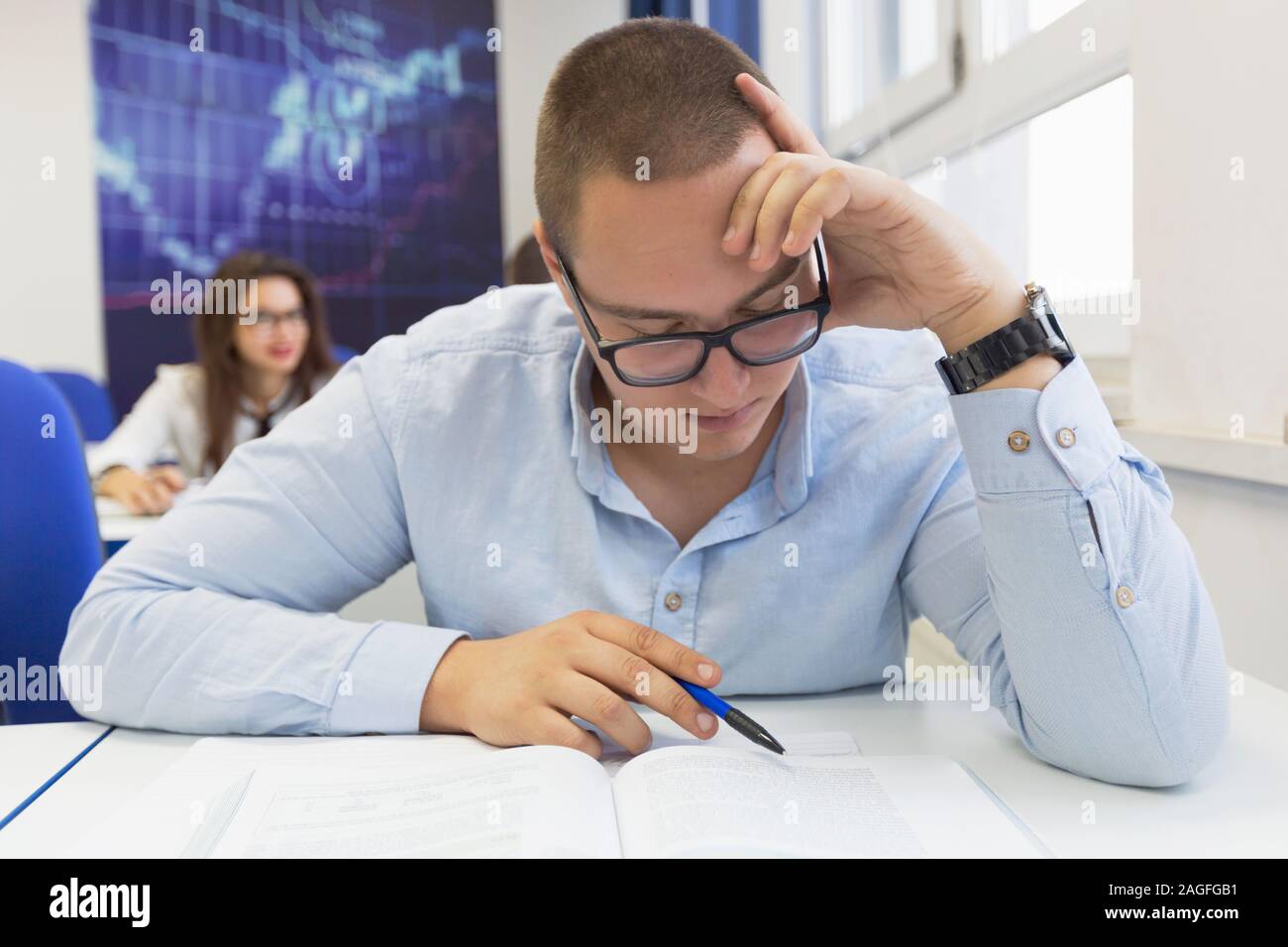 Youngmale student in math class overwhelmed by the math formula ...