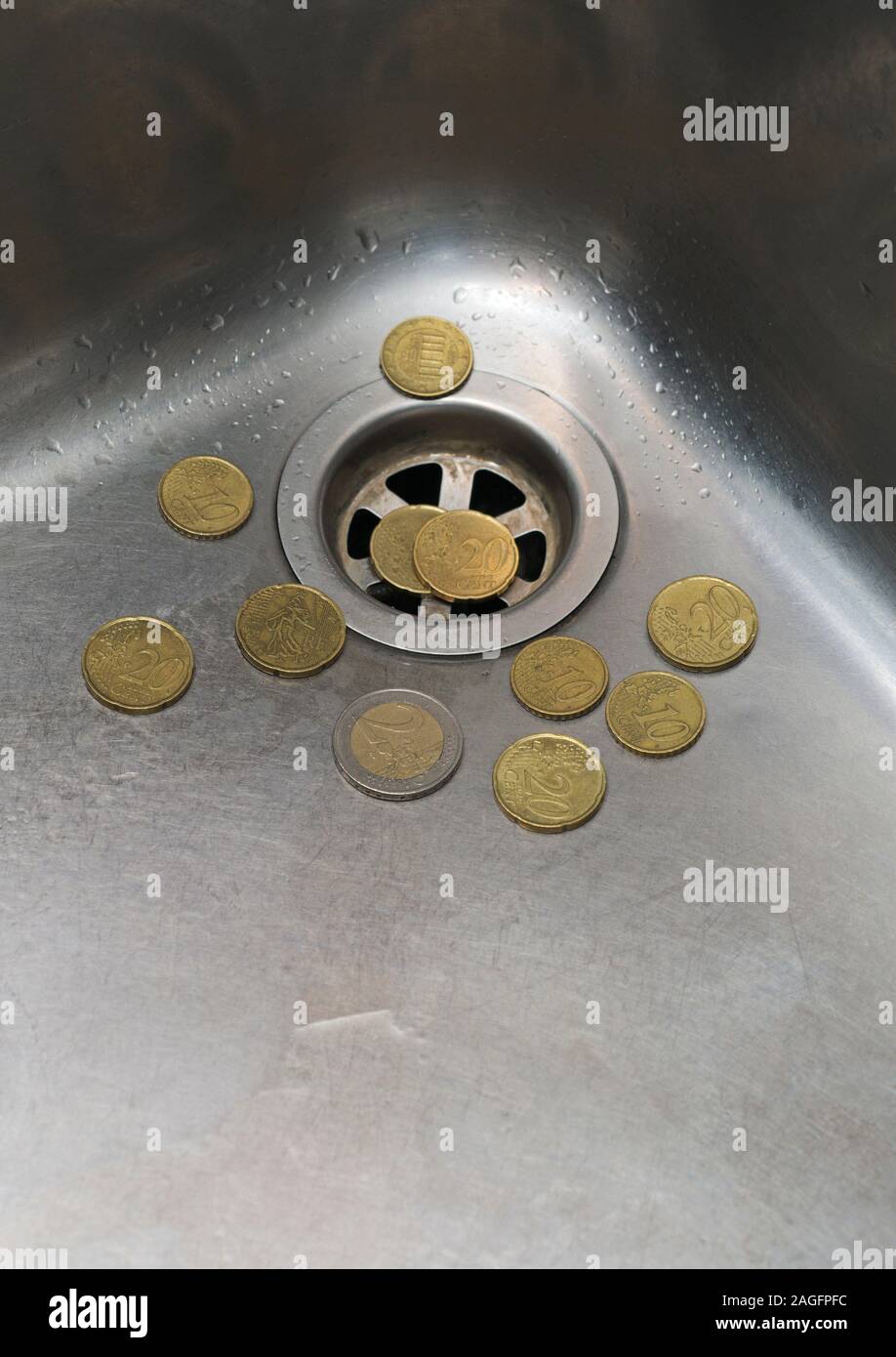 euro coins in the sink drain Stock Photo Alamy