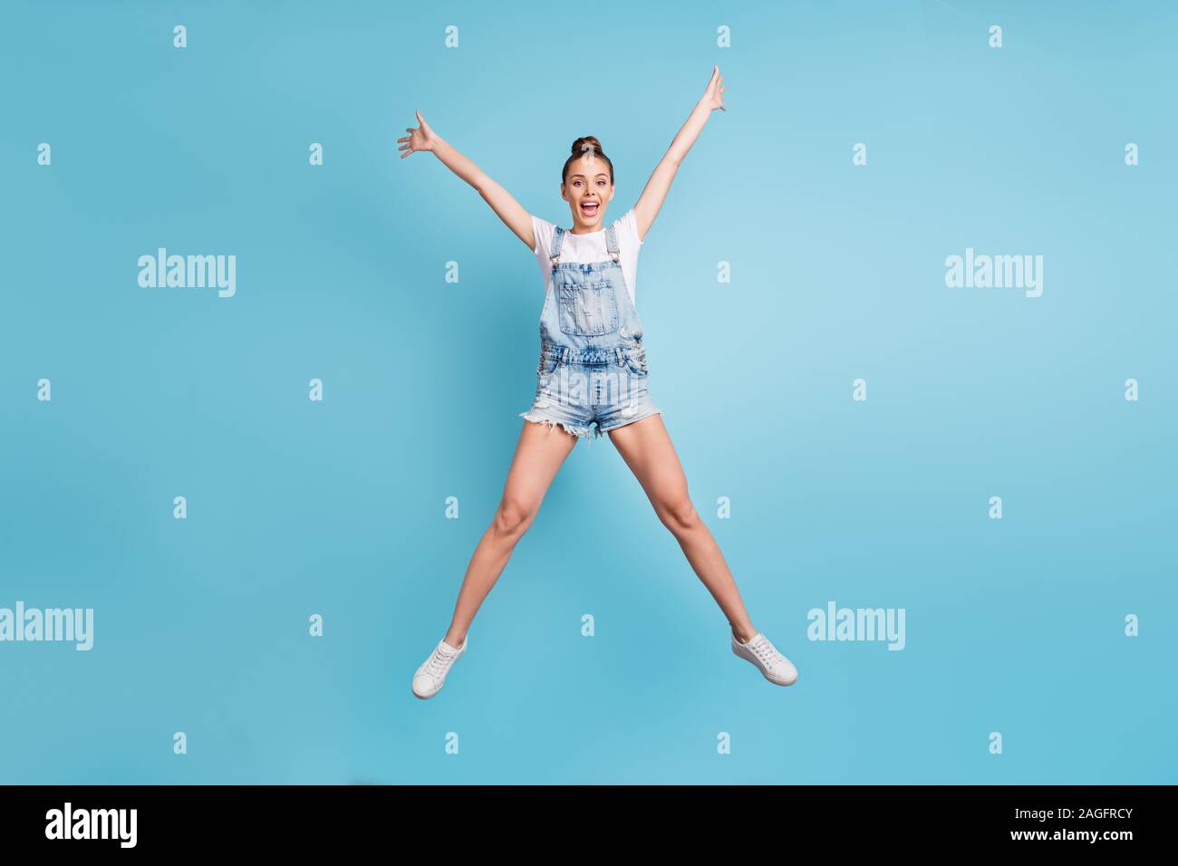 Full length body size photo of charming fascinating enjoying positive girl stretching away while isolated with blue background Stock Photo