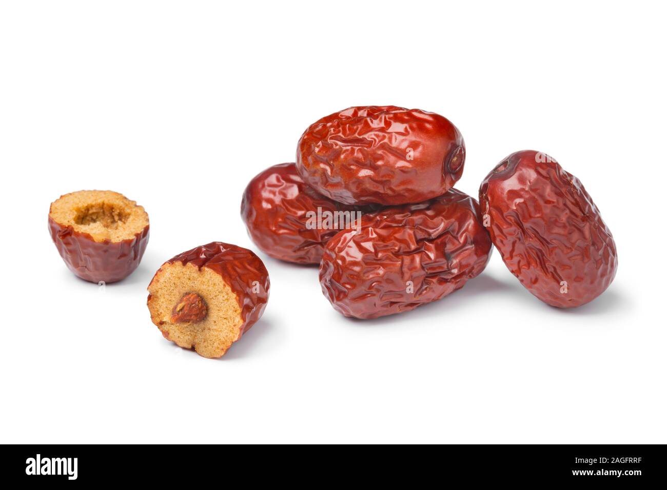 Heap of whole dried Chinese red dates and a halved one solated on white background Stock Photo