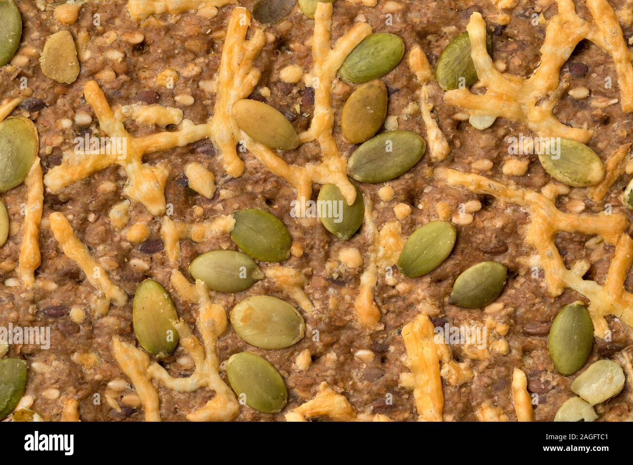 Close up of whole grain cheese cracker with pumpkin seed full frame Stock Photo