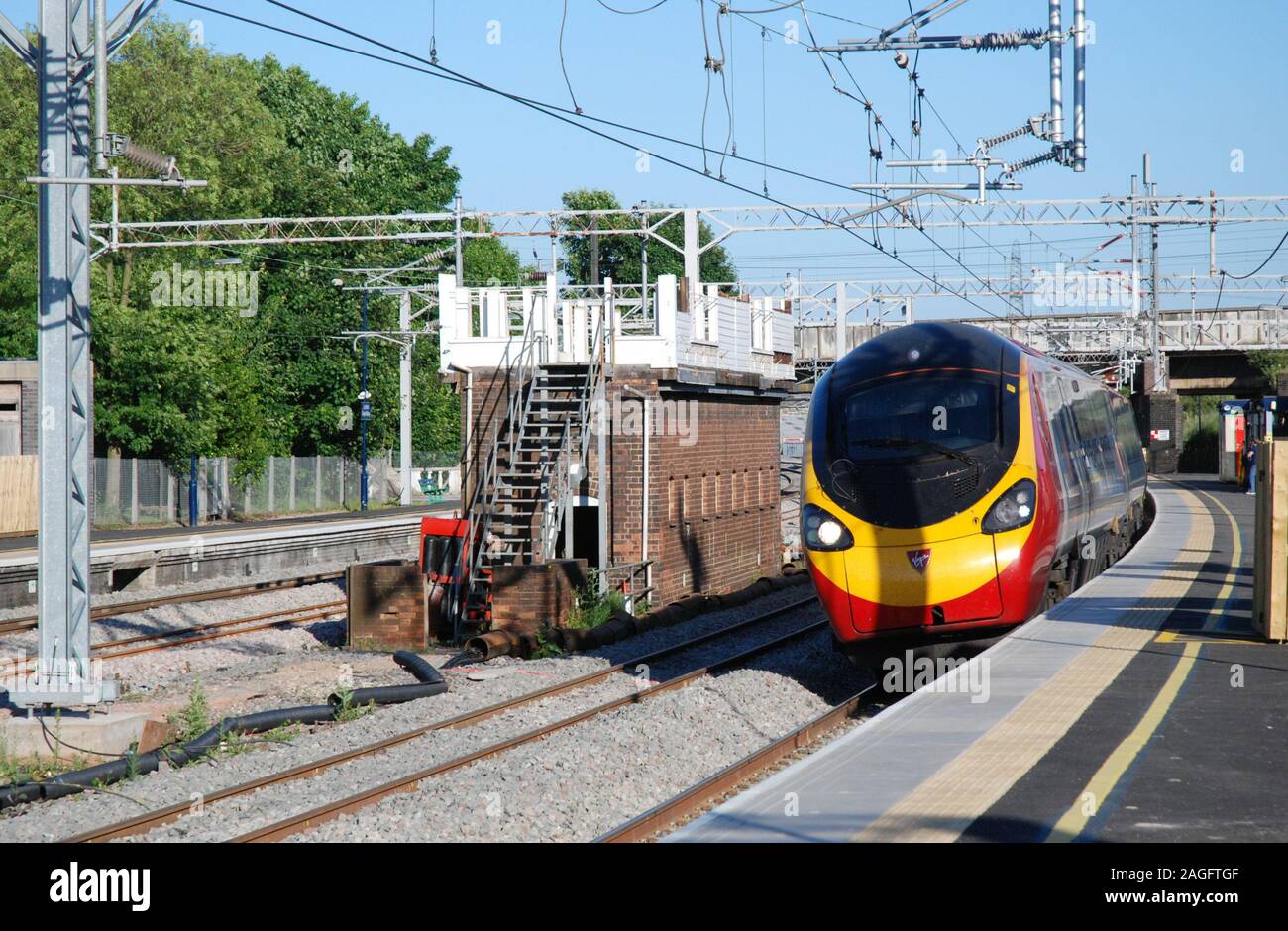 An unidentified Virgin Pendolino passes Lichfield Trent Valley Signal Box seen partially dismantled during the West Coast Main Line upgrade works. Stock Photo