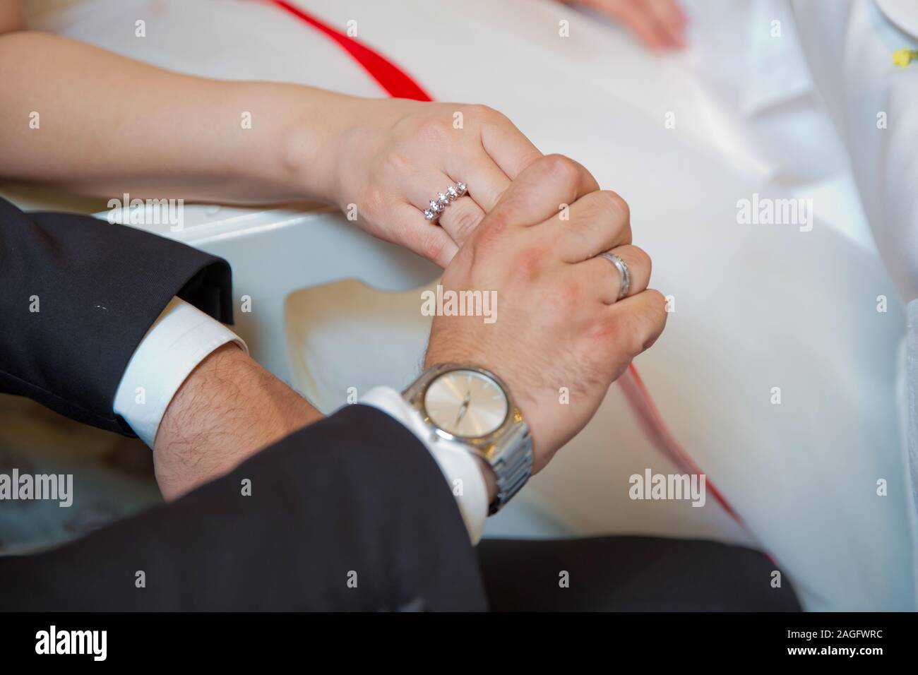 Bride and groom with Engagement gold rings put their hands on the table,  and next to them lies a wedding bouquet .Engagement flowers .The girl and  the Stock Photo - Alamy