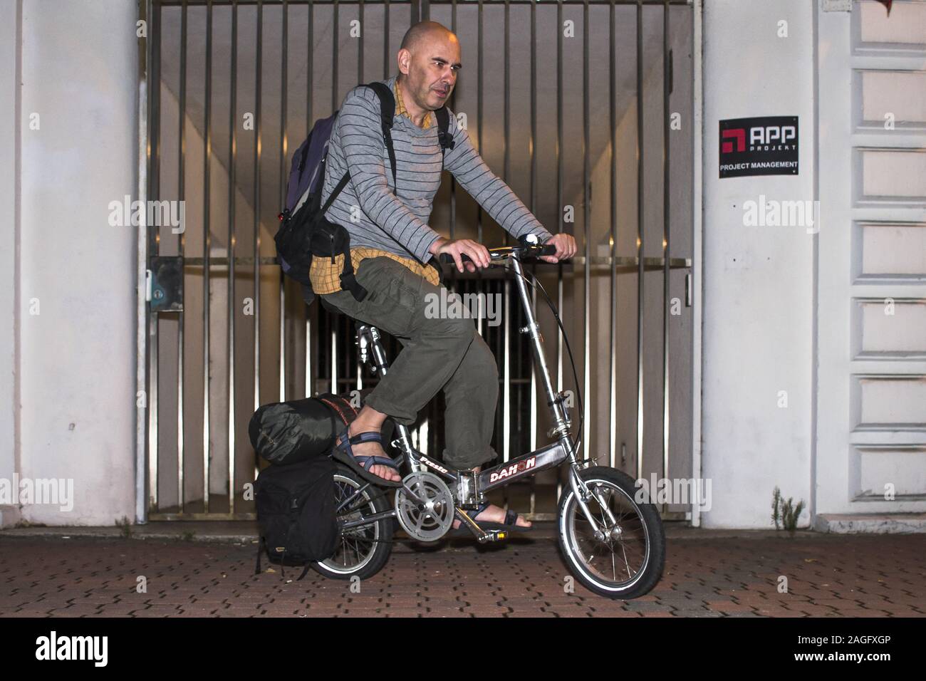 Mature man on a folded Dahon bicycle Stock Photo