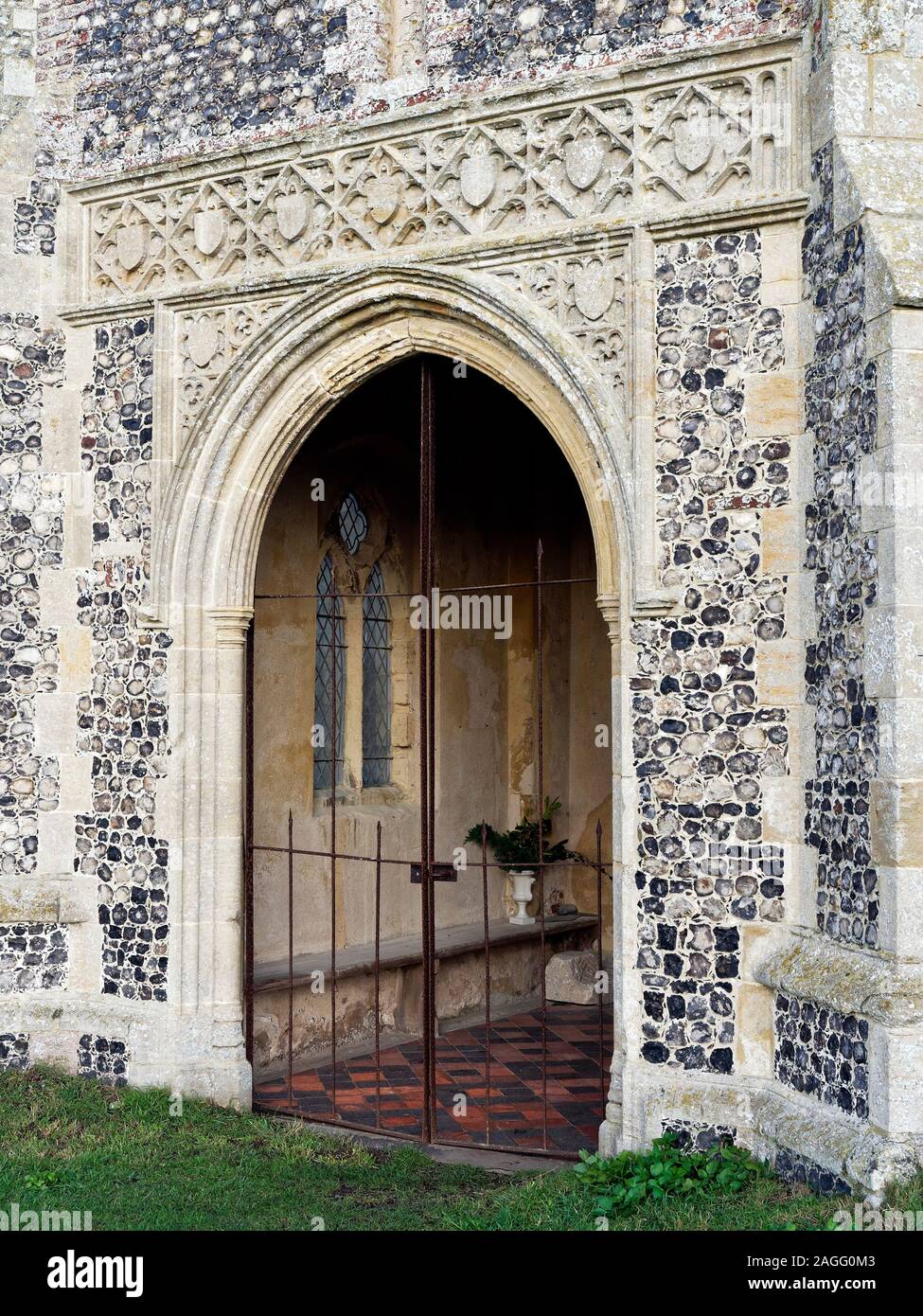 The porch of St John's church, Waxham, Norfolk, a crumbling and patched up medieval building behind the coastal sand dunes of north east Norfolk. Stock Photo