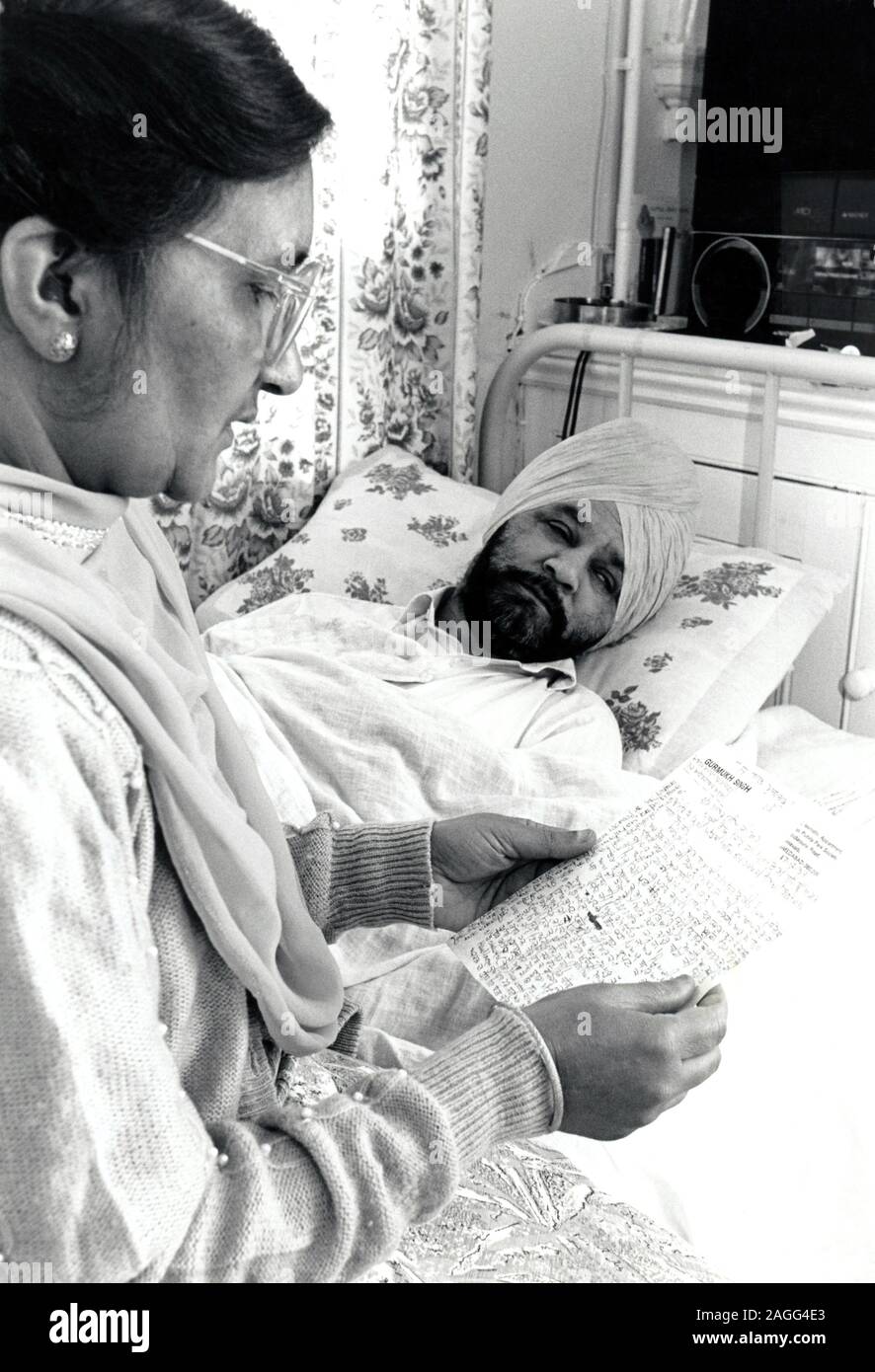 Elderly Asian woman caring for her husband, Nottingham UK 1990 Stock Photo