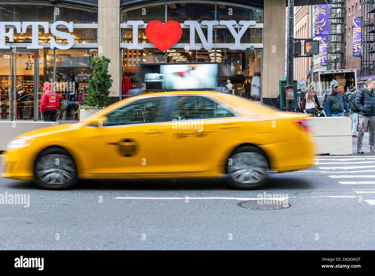I Love New York gift shop sign and blurred yellow taxi cab passing, Times Square, Manhattan, New York, USA Stock Photo