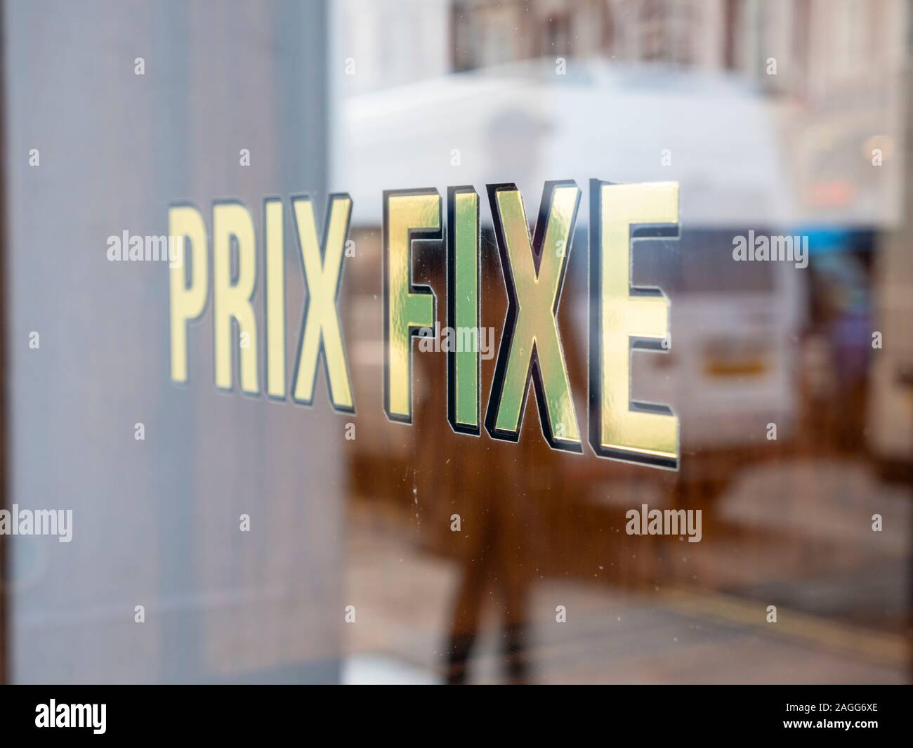 Prix fixe or fixed price adverts for food in a restaurant window in gold lettering on the window Stock Photo