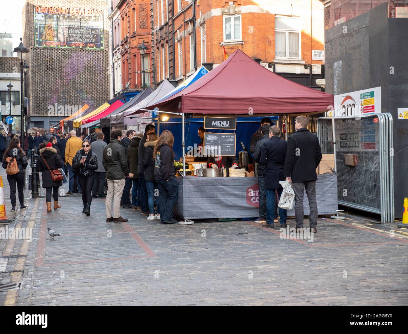 A street food market in Soho London UK with stalls selling food and