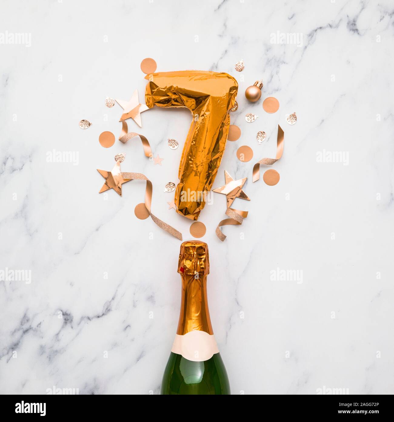 Champagne bottle with gold number 7 balloon. Minimal party anniversary concept Stock Photo