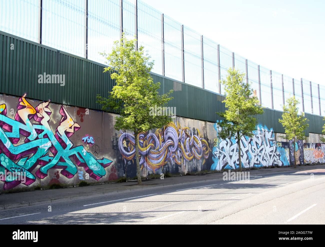 Colourful murals & graffiti on Peace wall,or Peace Line, running along Cupar Way in Belfast. It is one of the many separation barriers in N. Ireland Stock Photo