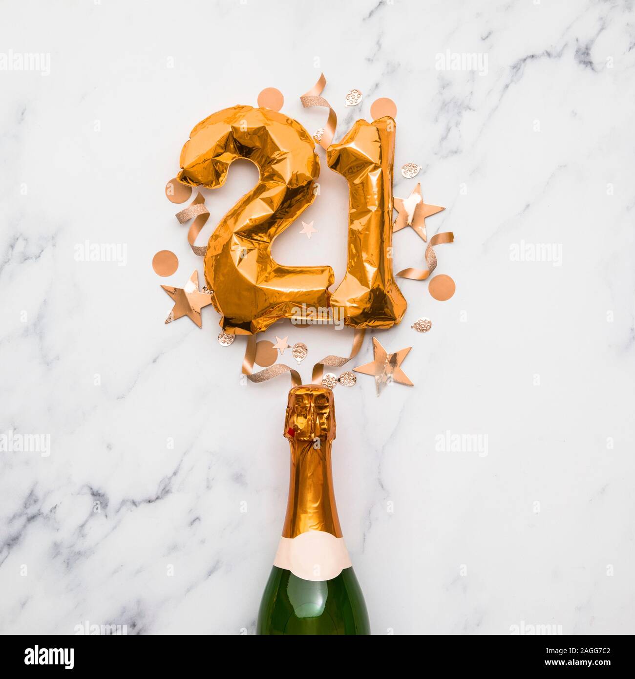 Champagne bottle with gold number 21 balloon. Minimal party anniversary concept Stock Photo