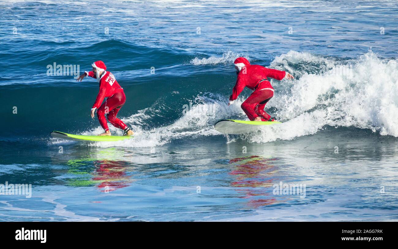 Las Palmas, Gran Canaria, Canary Islands, Spain.19th December, 2019. Surfing  Santas from the Mojo surf school enjoying their traditional early morning  festive surf from the city beach in Las Palmas. Credit: Alan