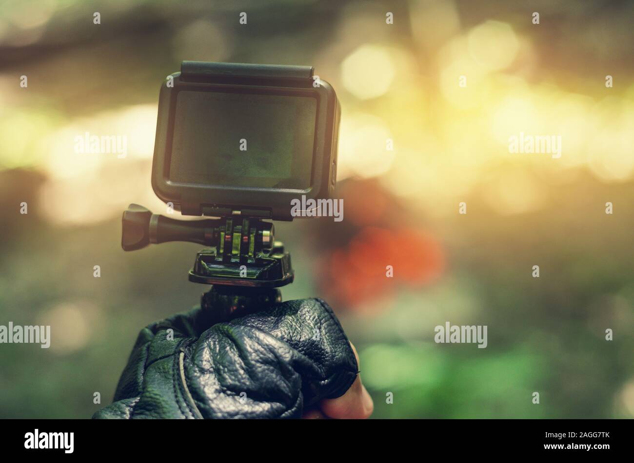 Action camera in hand in leather glove. Stock Photo