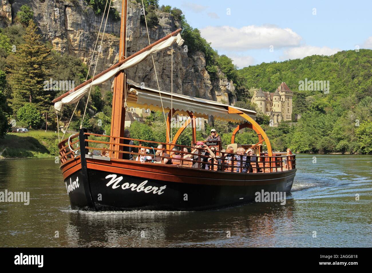 Boat trip, flat-bottomed boat on the Dordogne River in Vezac, in the Perigord noir region (south-western France) in the background, the Castle of La Stock Photo