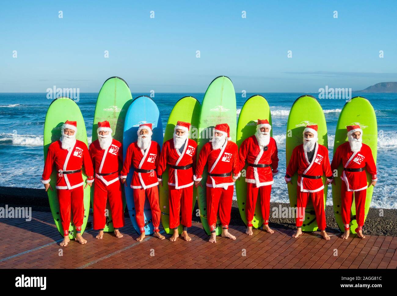 Las Palmas, Gran Canaria, Canary Islands, Spain.19th December, 2019. Surfing  Santas from the Mojo surf school head out for their traditional early  morning festive surf from the city beach in Las Palmas.