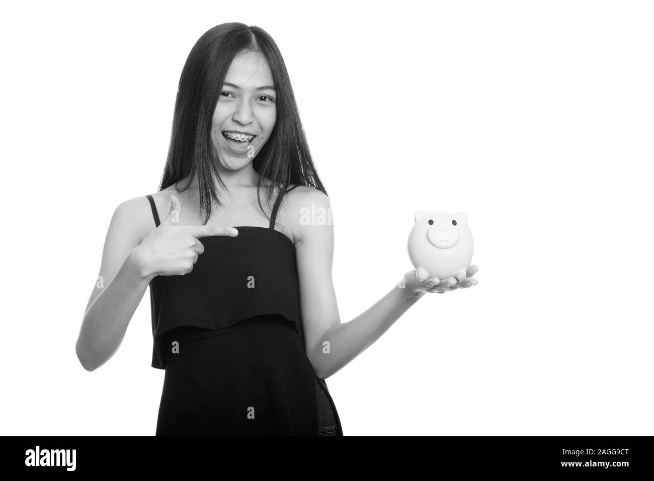 Young happy Asian teenage girl smiling while holding piggy bank and ...