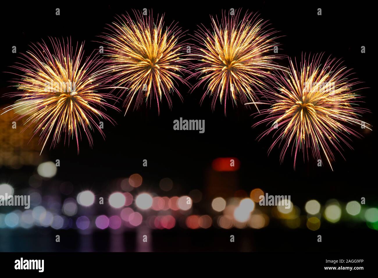 Colorful fireworks celebration on miidnight sky and the city night light background. Stock Photo
