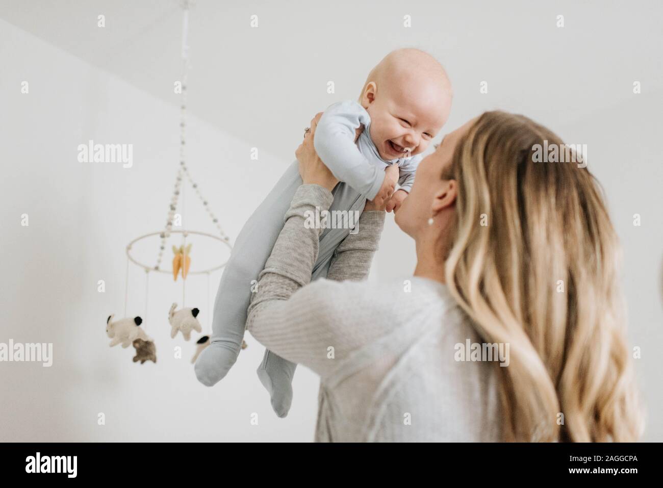 Mother throwing baby boy in air in bedroom Stock Photo Alamy