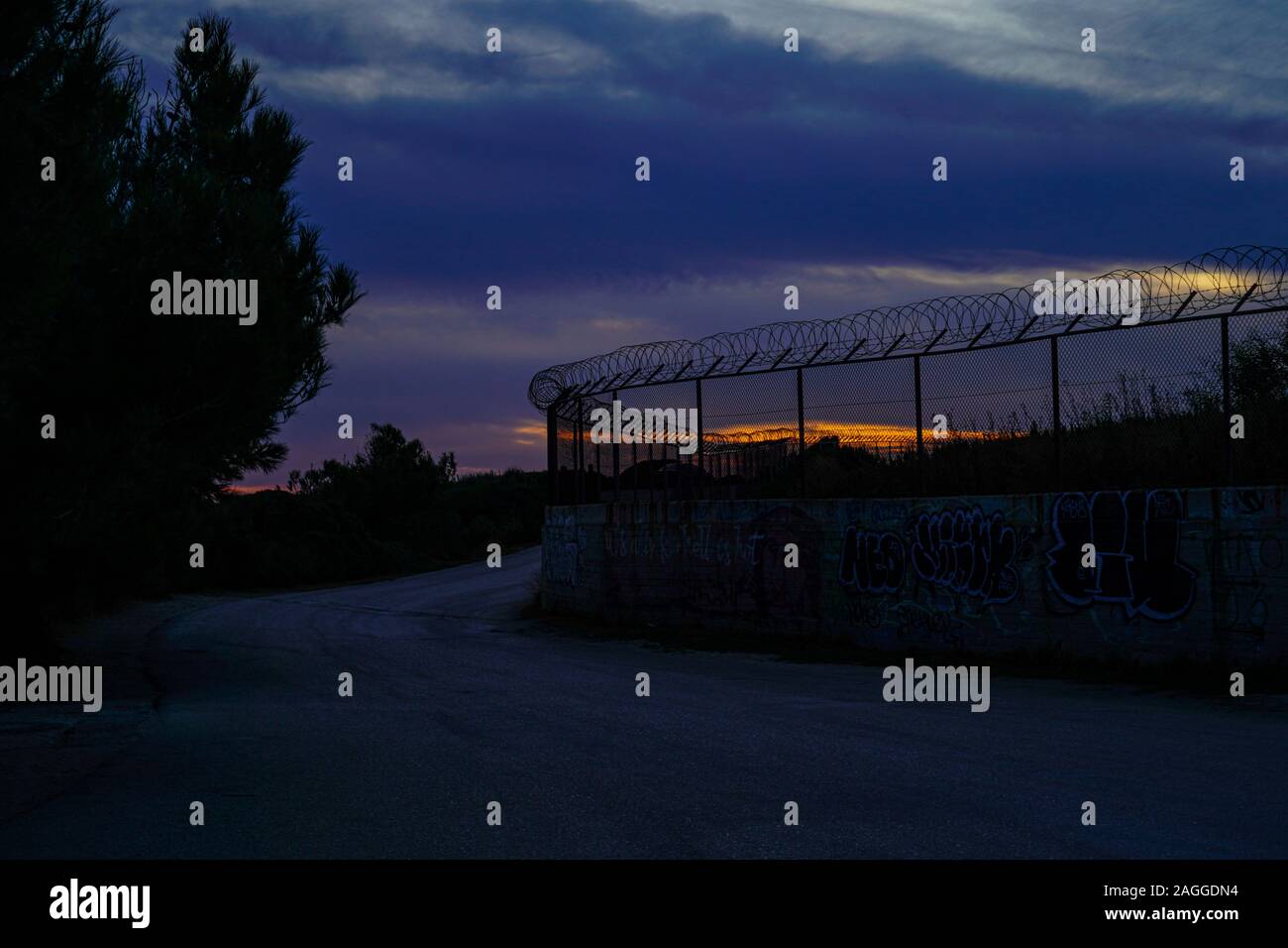 Barbed wire fence at sunset Photographed on Cephalonia, Ionian Islands, Greece Stock Photo