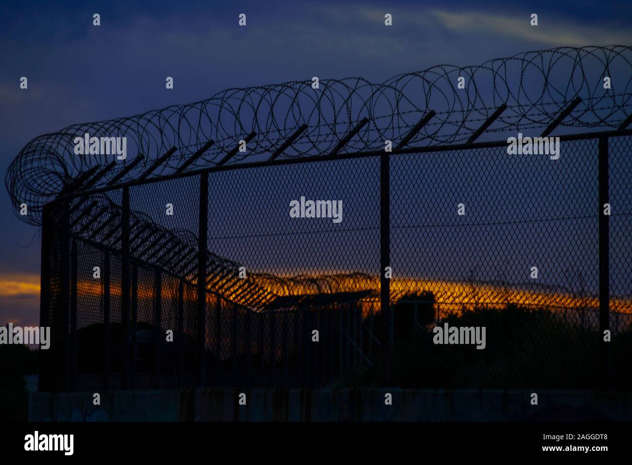 Barbed wire fence at sunset Photographed on Cephalonia, Ionian Islands, Greece Stock Photo