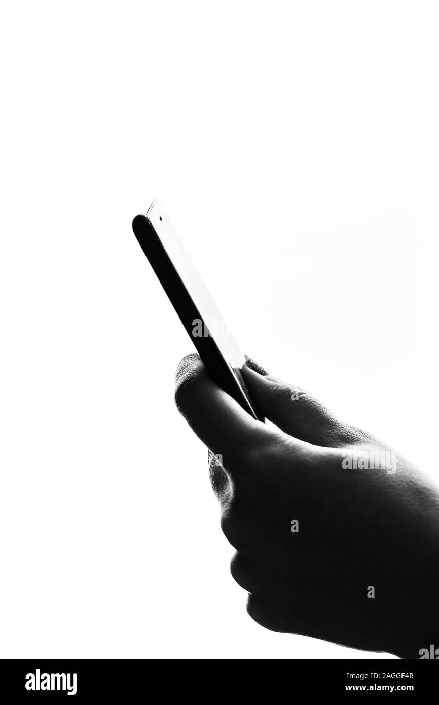 Woman hand holding a black smartphone in her hand. Teenage girl using a touchscreen smartphone, isolated on white Stock Photo