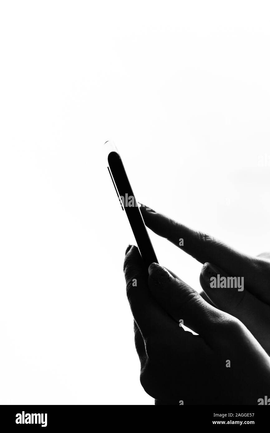 Woman hand holding a black smartphone in her hand. Teenage girl using a touchscreen smartphone, isolated on white Stock Photo