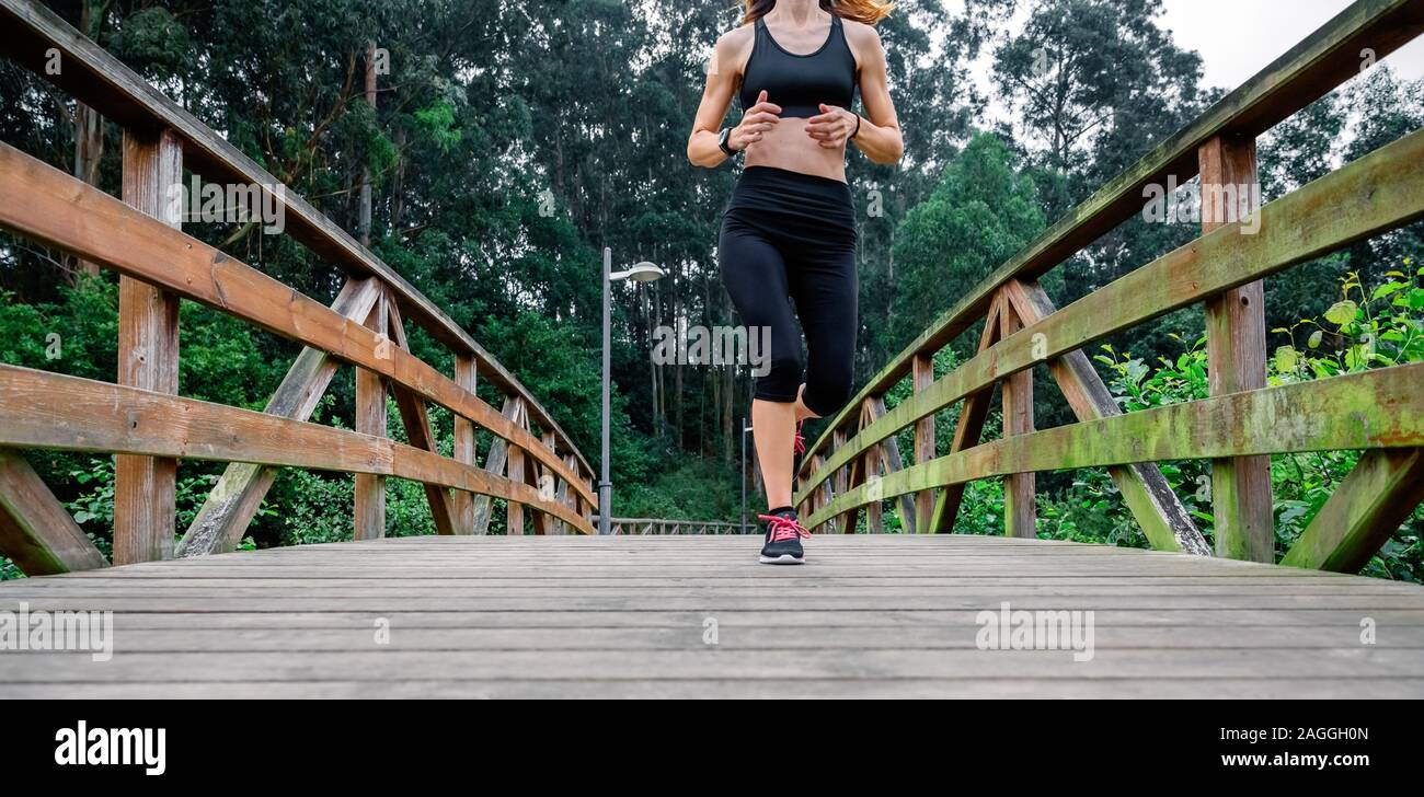 Woman running through an urban park Stock Photo