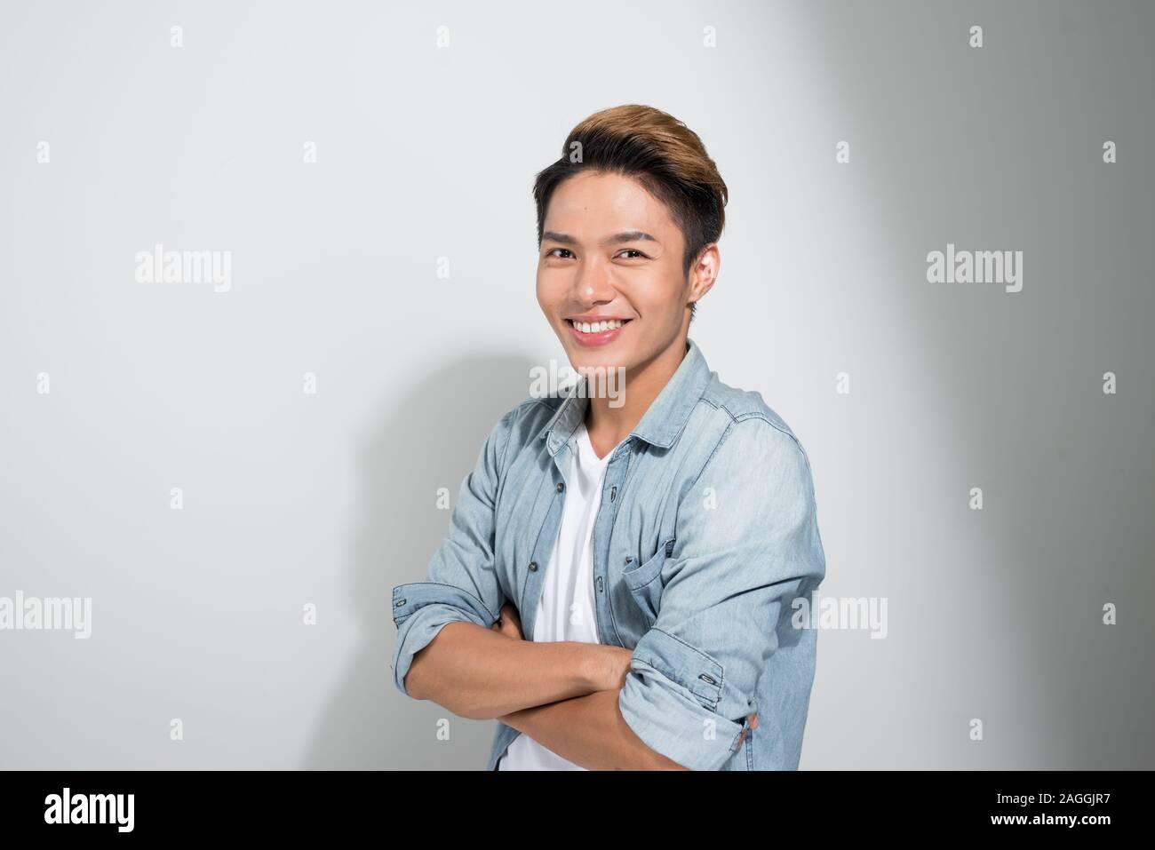 Asian Confident young handsome man in jeans shirt keeping arms crossed ...