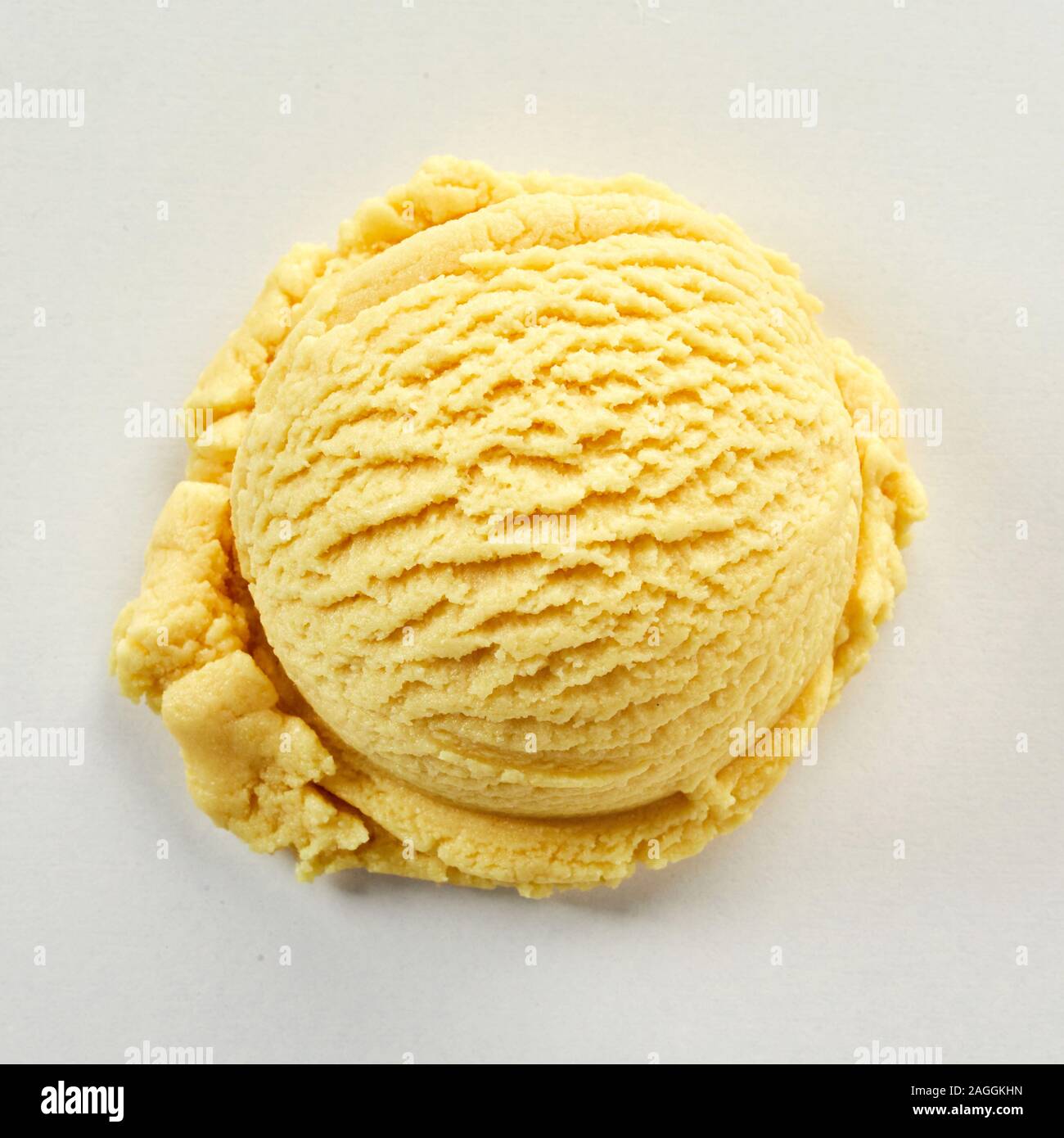 Scoop of yellow ice cream with banana flavour, viewed in close-up on grey background Stock Photo