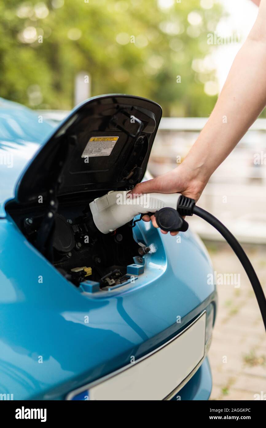 Man holding in hand power cable supply ready to plugged in into charging port Stock Photo Alamy