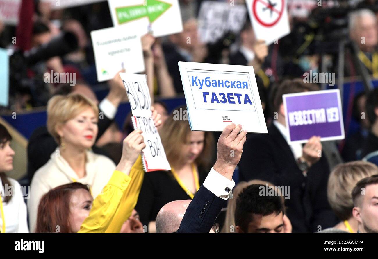 Moscow, Russia. 19 December, 2019. Reporters compete to be called on during the annual year end news conference by Russian President Vladimir Putin December 19, 2019 in Moscow, Russia. During the event Putin denounced the impeachment of Donald Trump, questioned the causes of climate change and hinted he may remain in power past 2024.  Credit: Kremlin Pool/Kremlin Pool/Alamy Live News Stock Photo