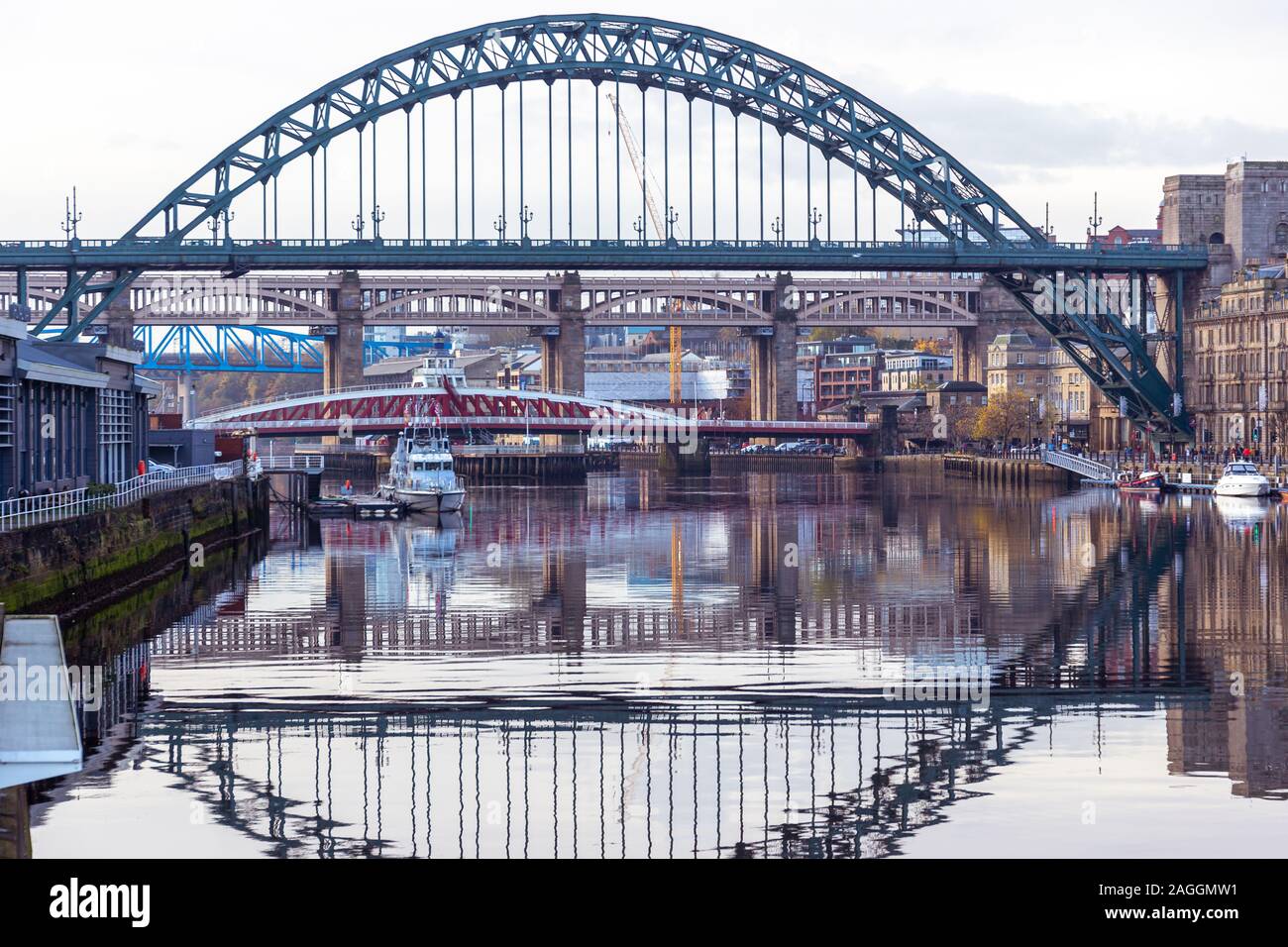 Newcastle, England - November 09 2019: Tyne Bridge mirrored in the River Tyne, Newcastle, UK with Swing, Queen Elizabeth IIand High Level bridge in the background Stock Photo