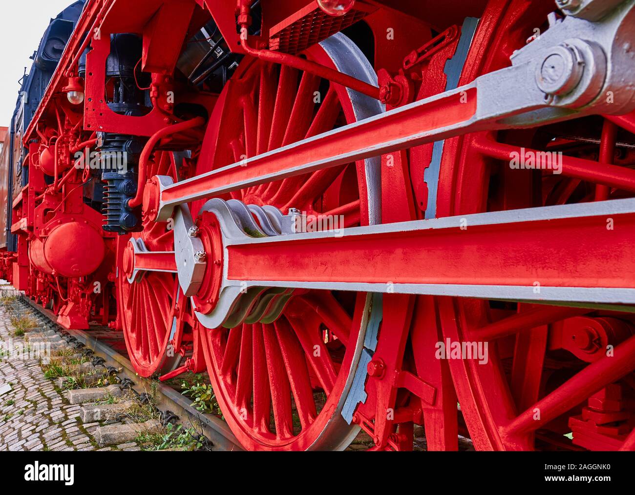 Red iron wheels and connecting rods of a historic locomotive Stock Photo